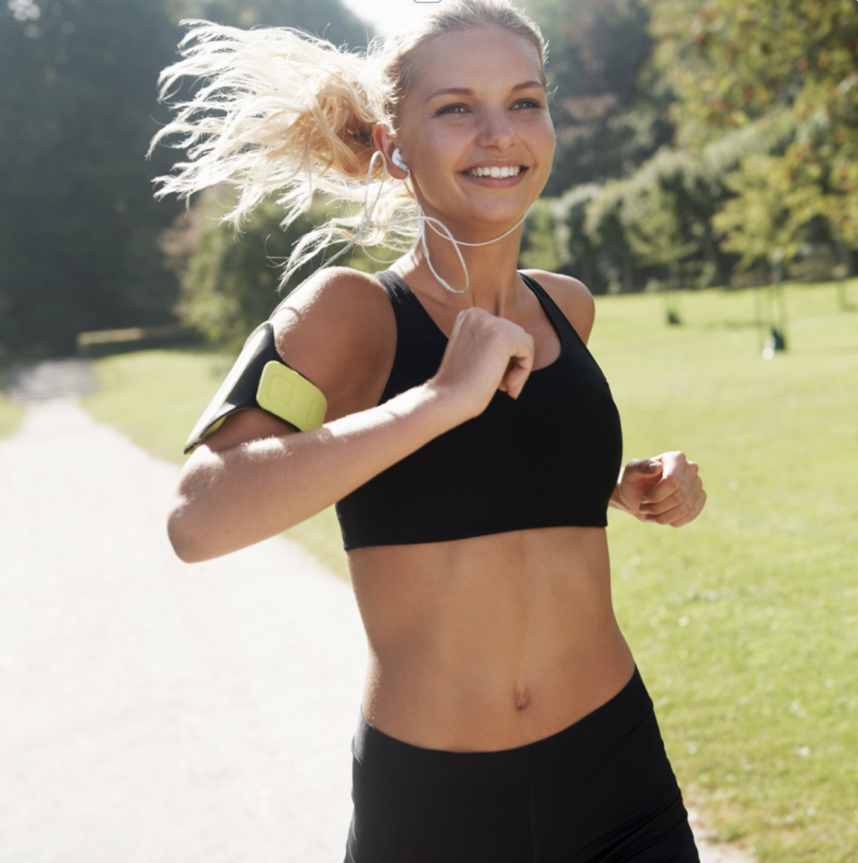 Woman running a park and smiling